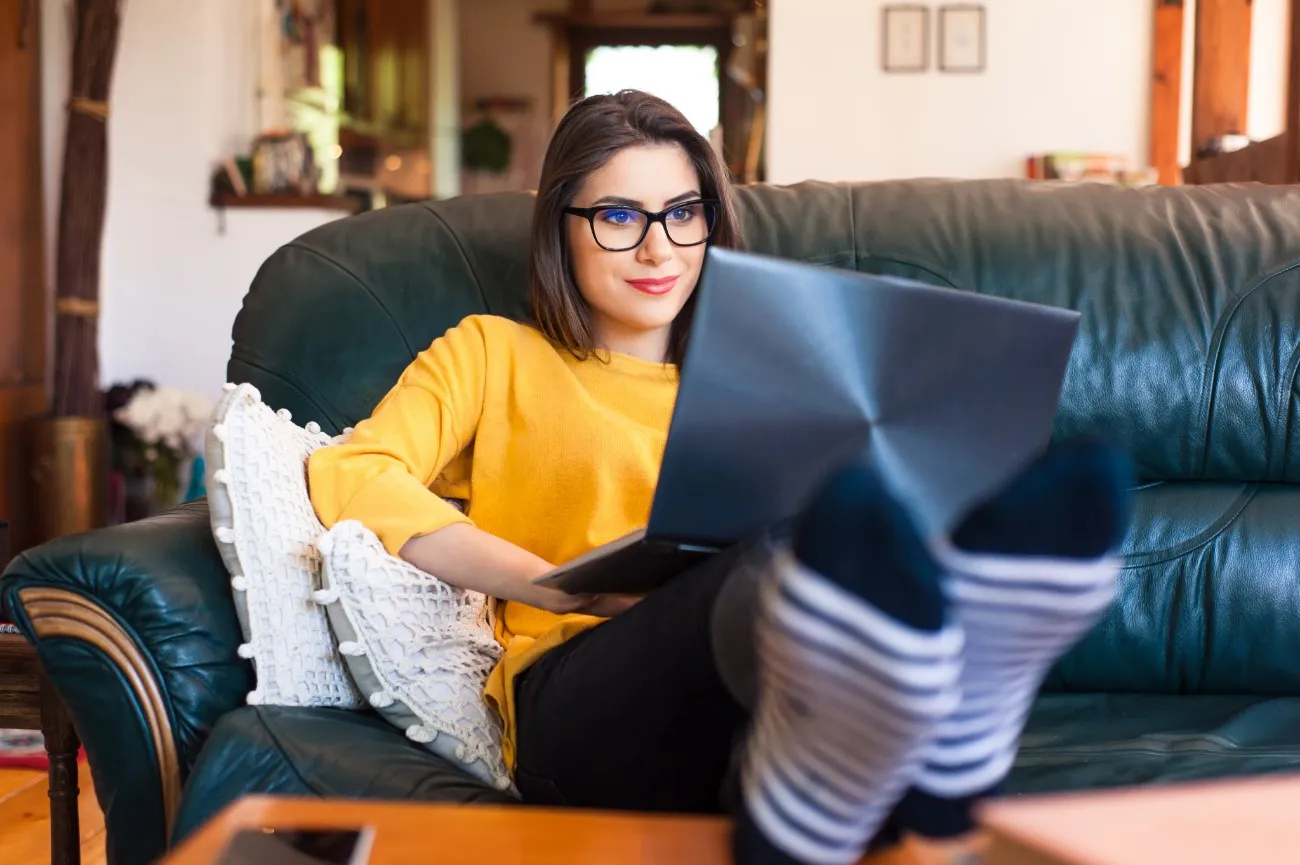 woman lounging on couch with laptop