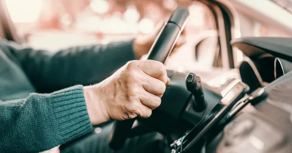 senior's hands on steering wheel