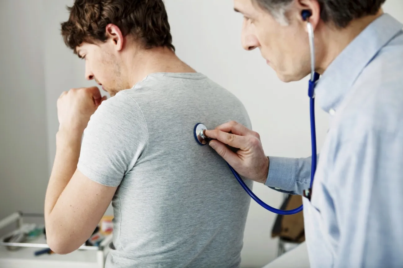 man coughing, doctor checking heartbeat