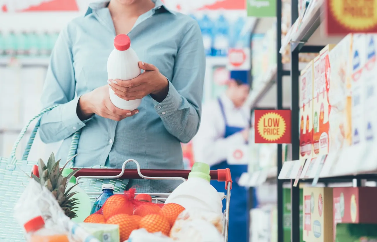 woman reading nutrition label at grocery store