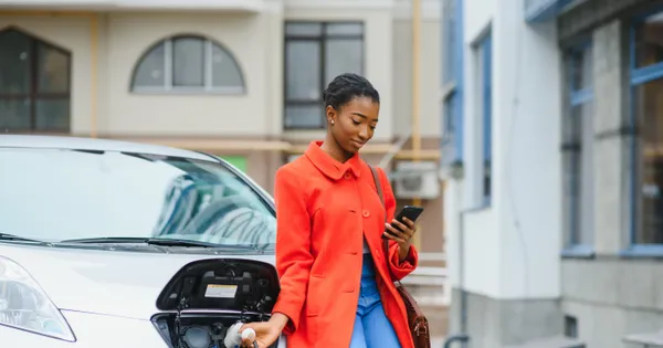 Young woman charging her EV