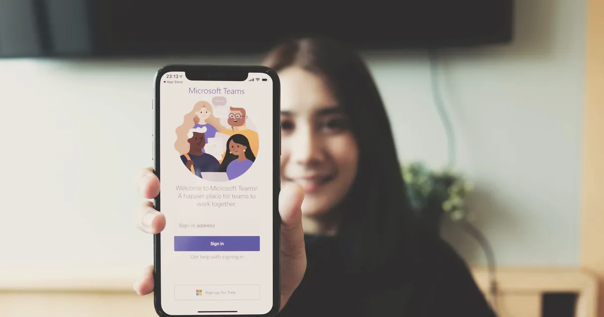 Woman showing Microsoft Teams software on smartphone
