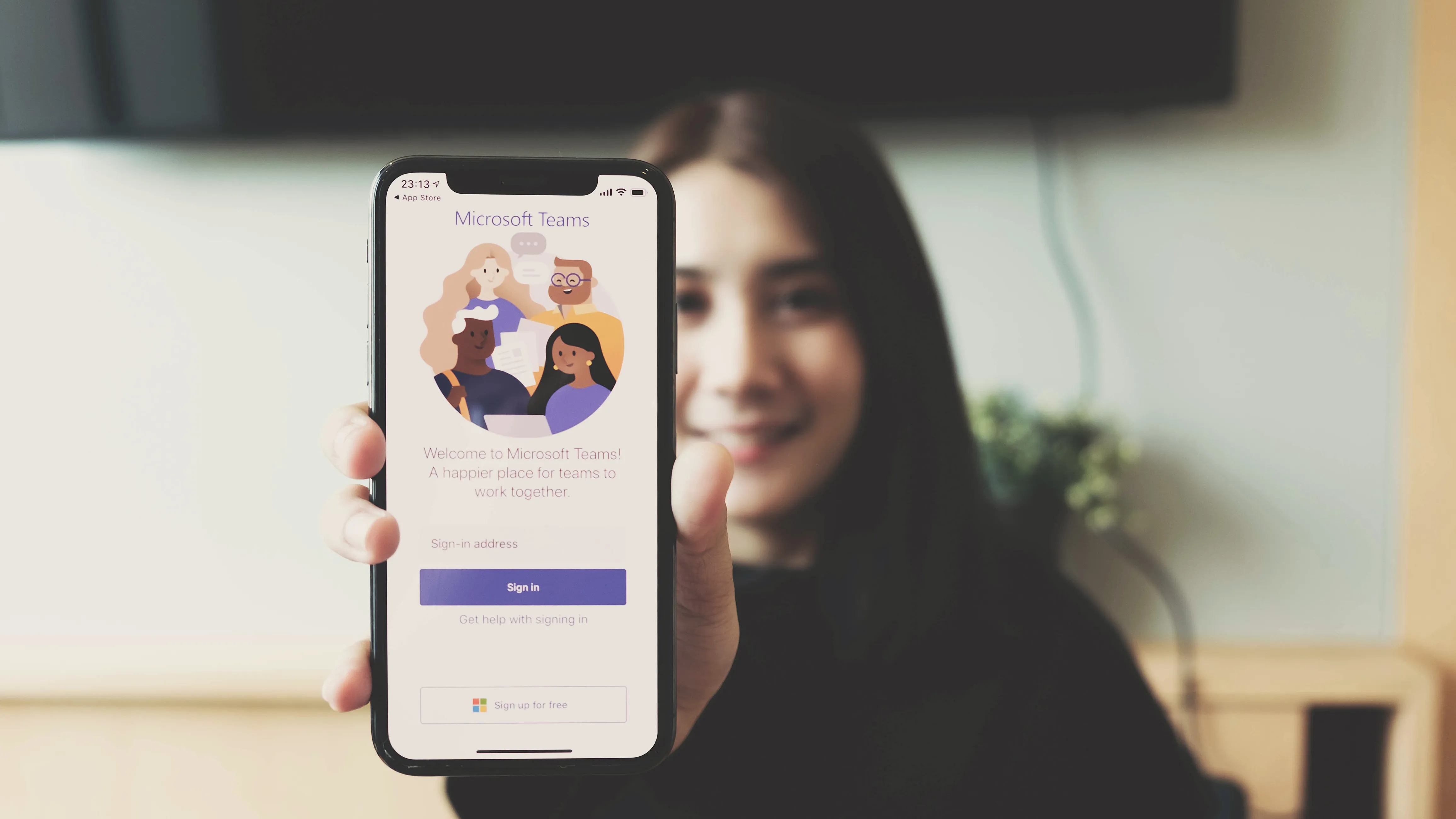 Woman showing Microsoft Teams software on smartphone