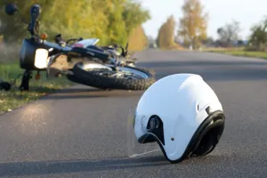 motorcycle and helmet laying on the street