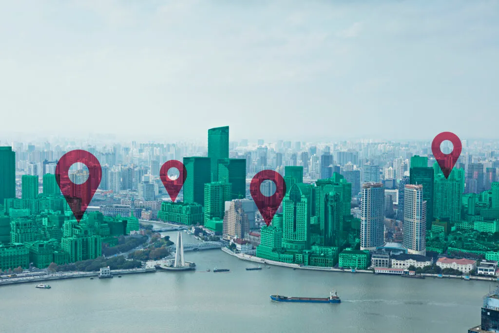 Digital composite image of map pin flat over green cityscape and Huangpu River against sky