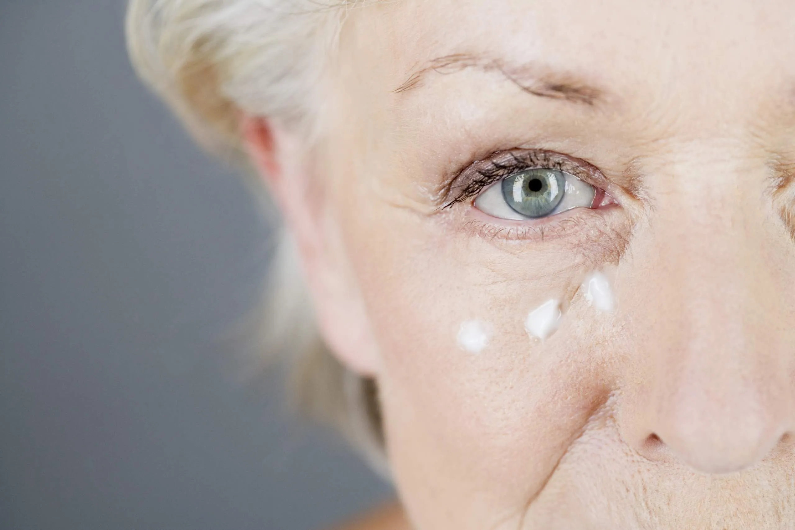 senior woman with cream dotted under eyes