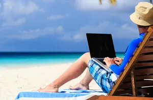 man with laptop on tropical vacation