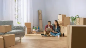 couple on apartment floor with packages around them