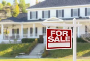 for sale sign in front of a house