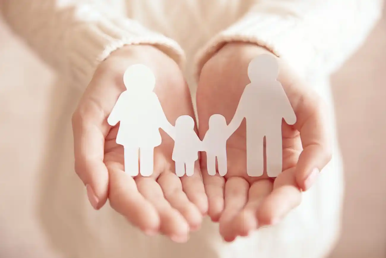 Woman Holding Paper Family in Hands