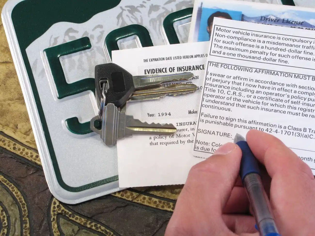 Signing Car Insurance Application with Keys and License