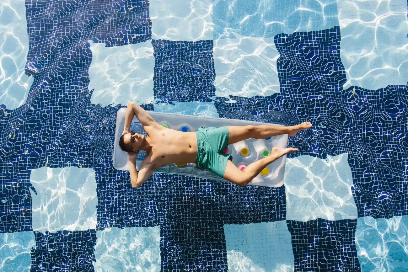 Man Floating in Pool on Vacation