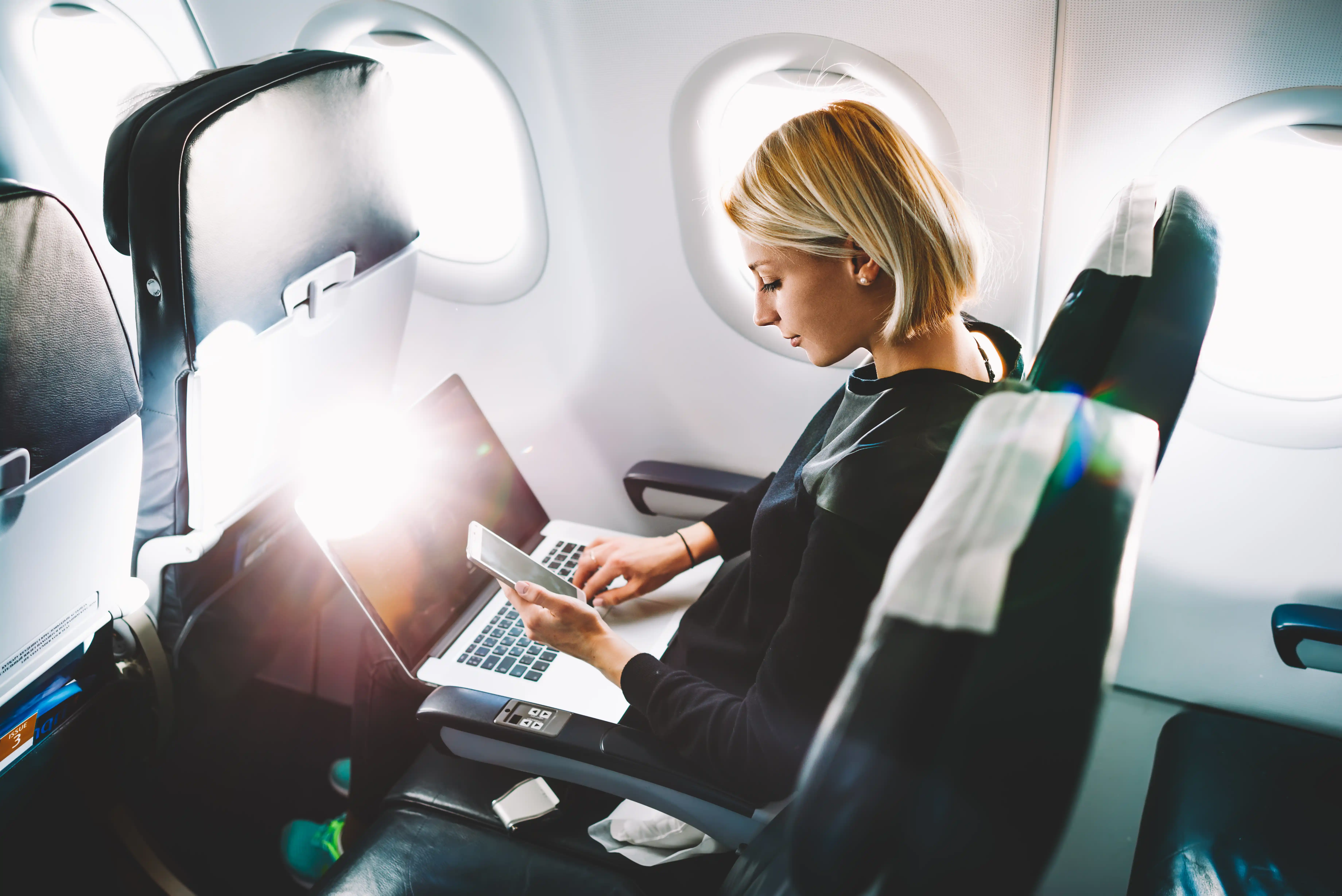 Woman Working on Computer on a Plane