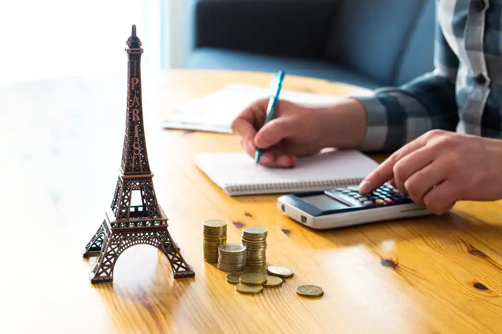 Eiffel Tower and Coins on Travel Agents Desk