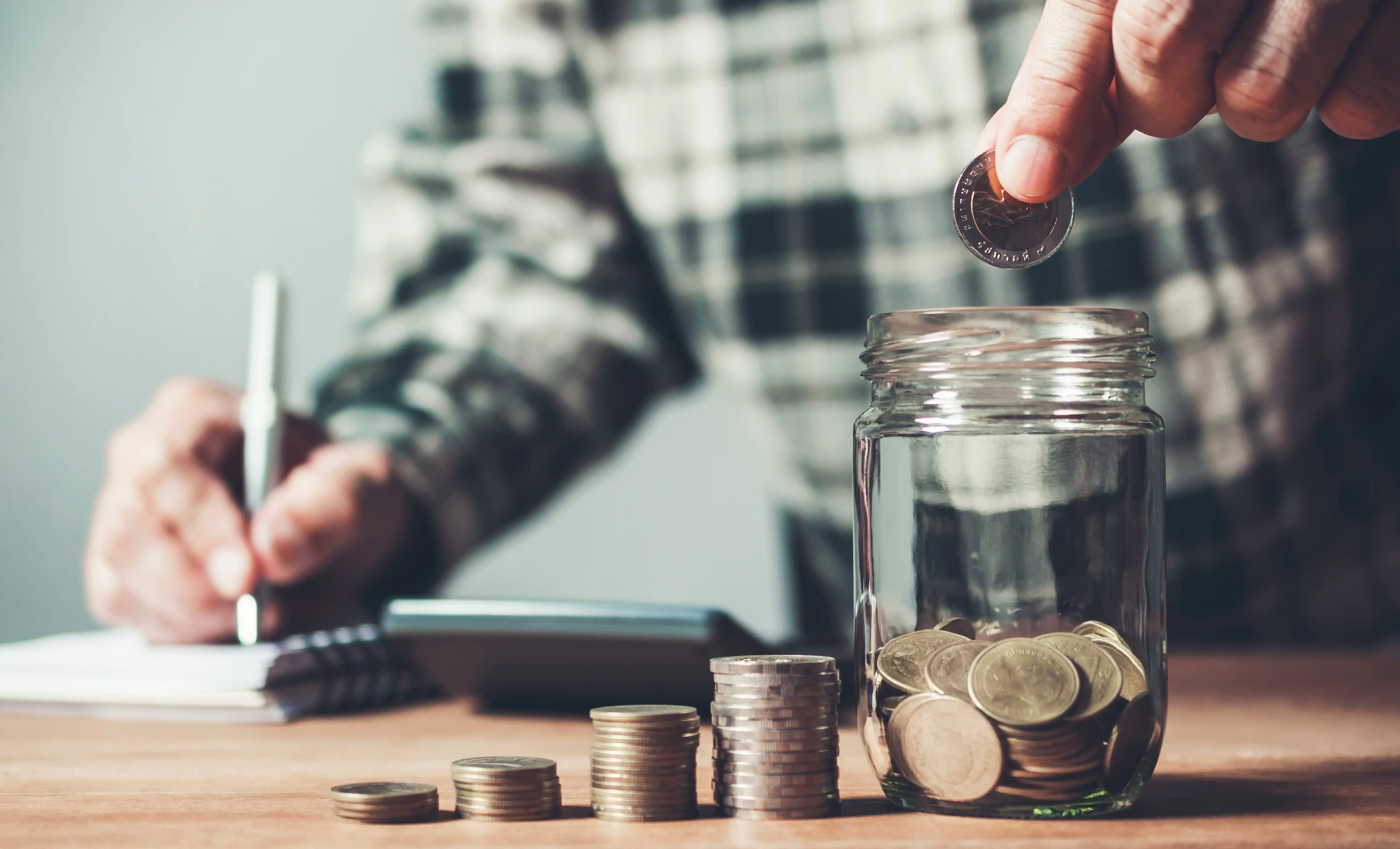 Man Saving Coins in Money Jar