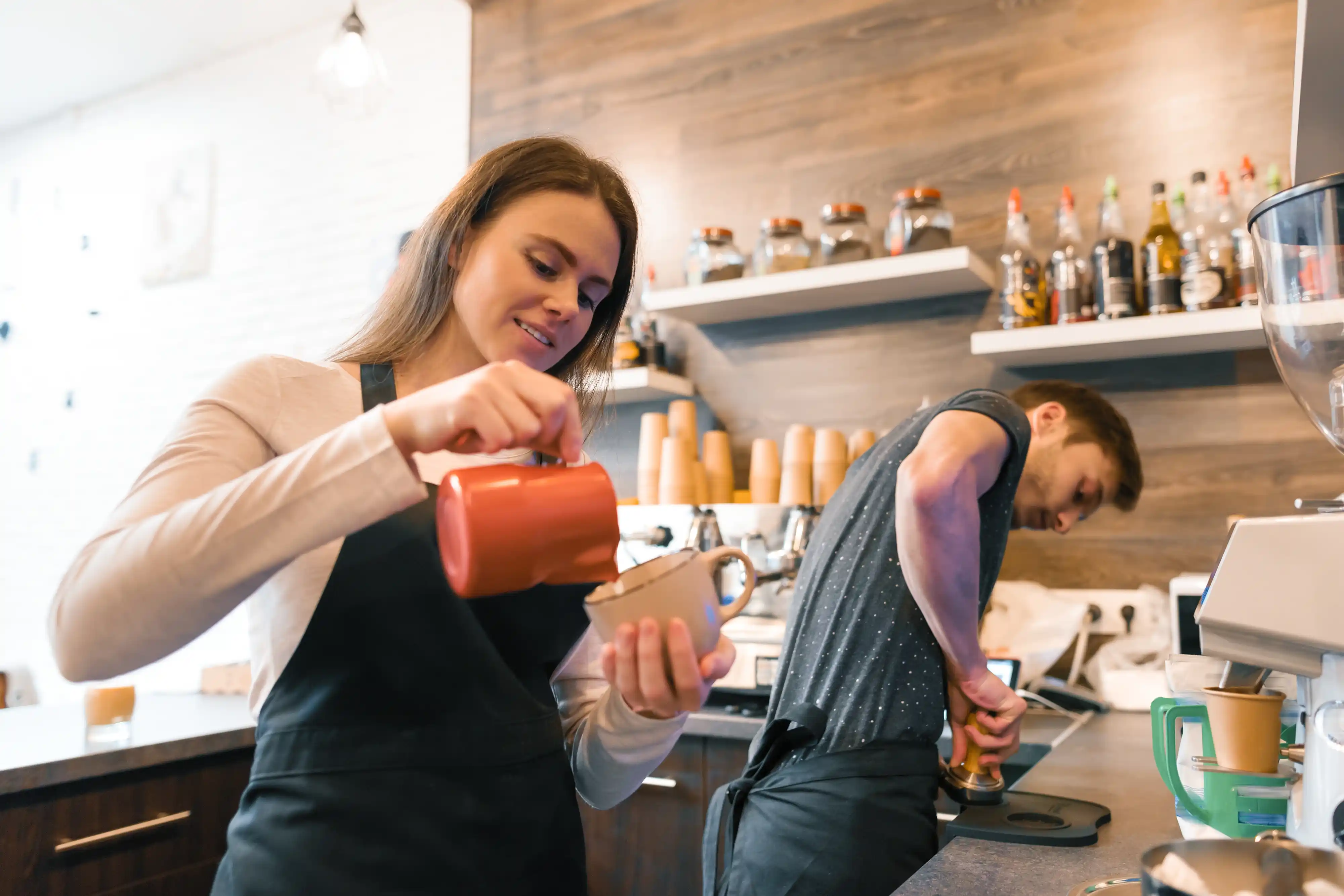 Woman Working as a Barista Pouring Coffee