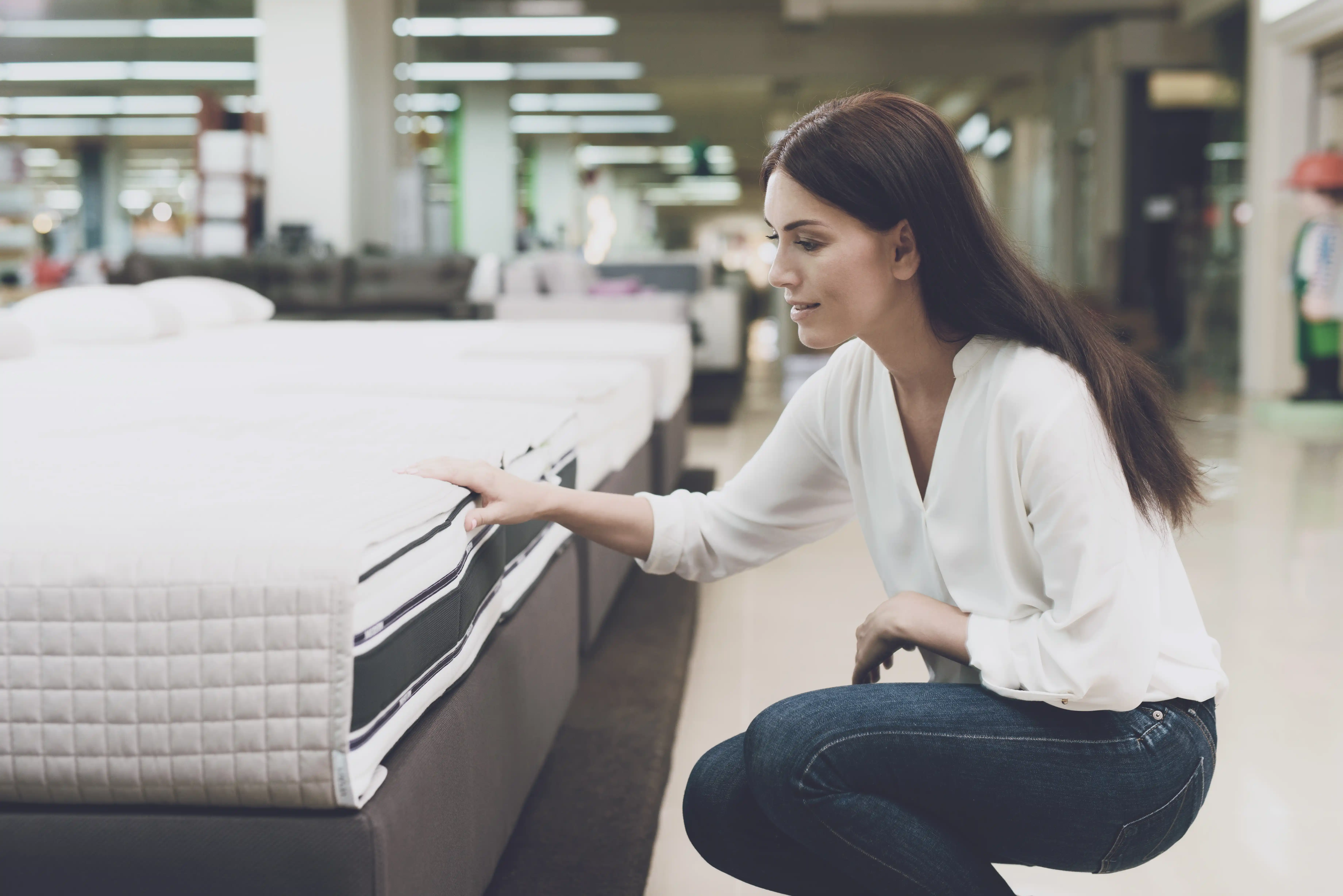 Woman Examining Mattress