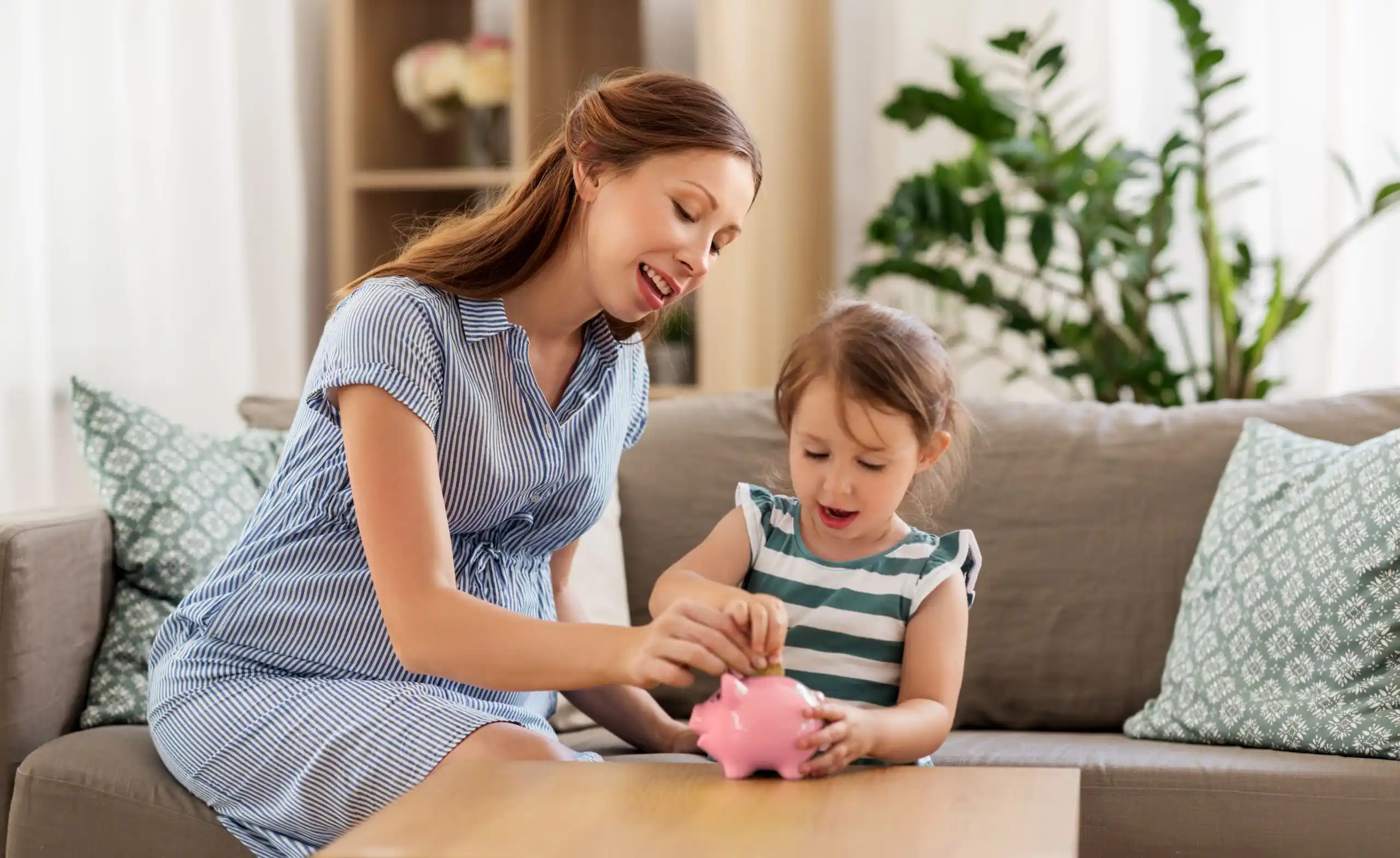 Single Mom and Child Putting Money in Piggy Bank