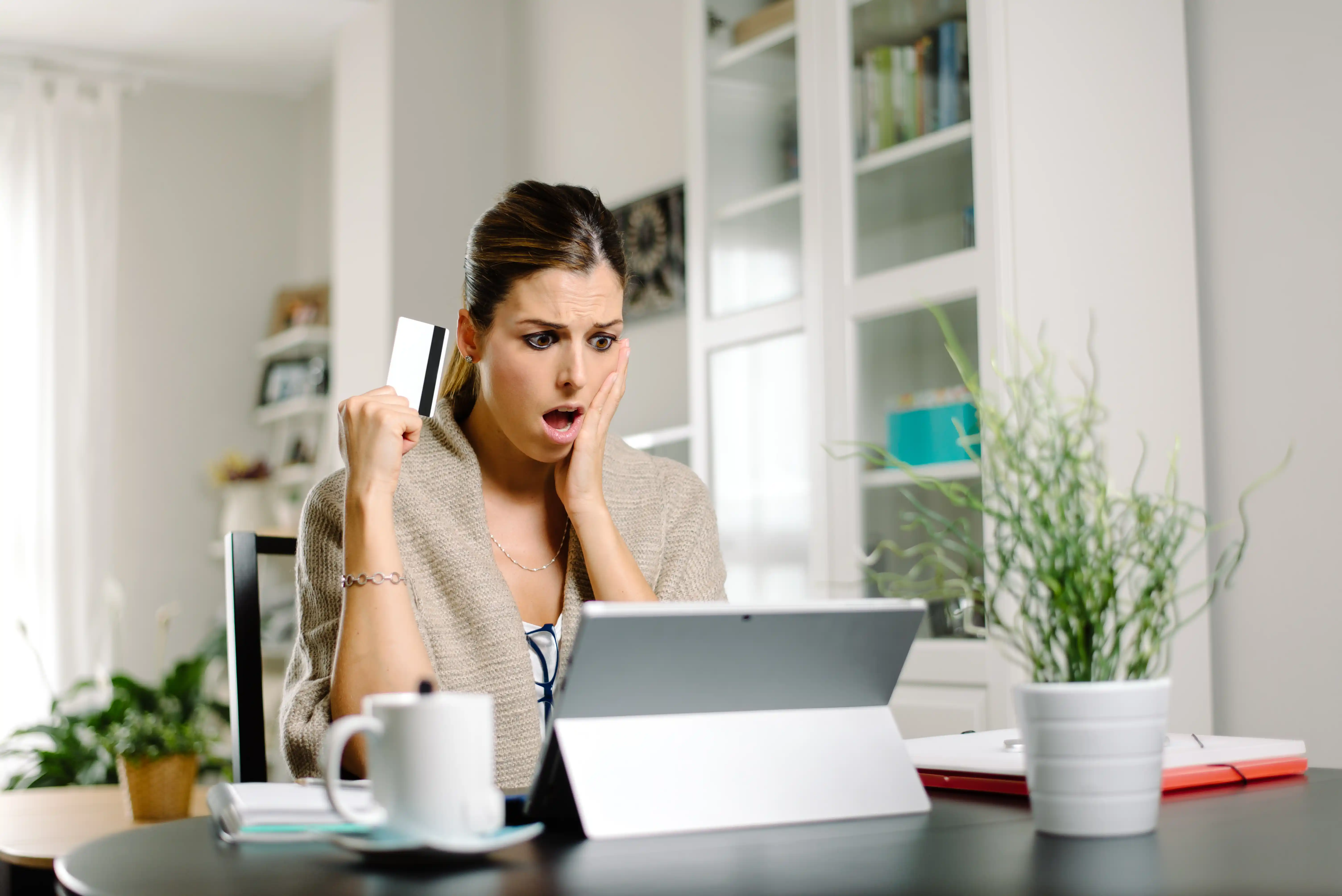 Woman Shocked with Credit Card in Hand