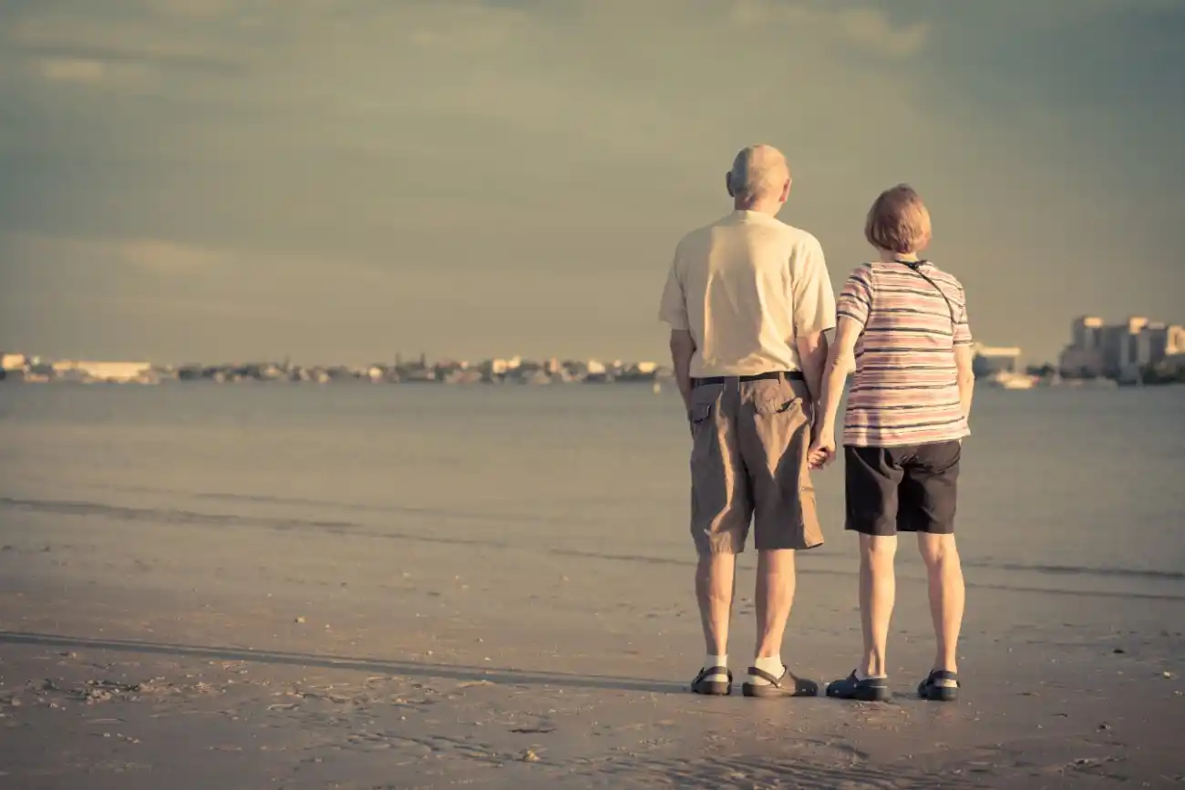 Retired Senior Couple Holding Hands at the Beach