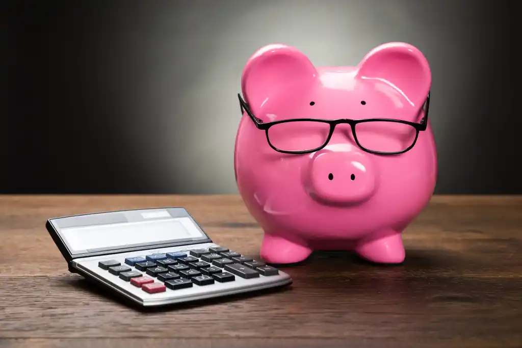 Piggy Bank and Calculator on Table