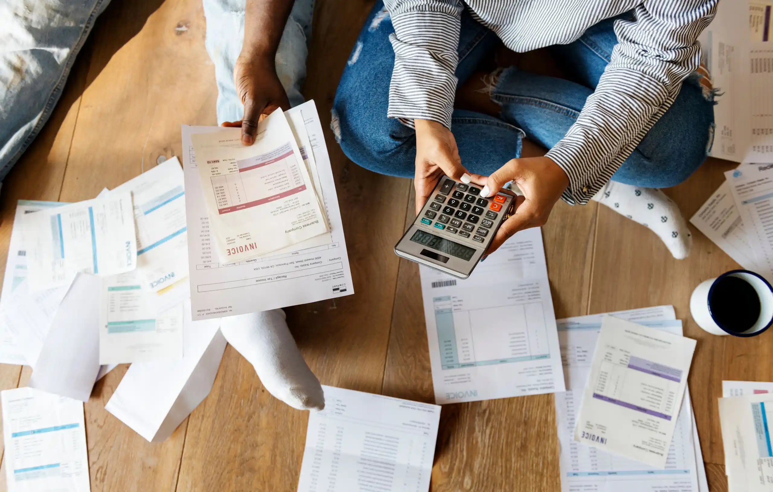 Calculating Debt with Invoices on Wood Floor