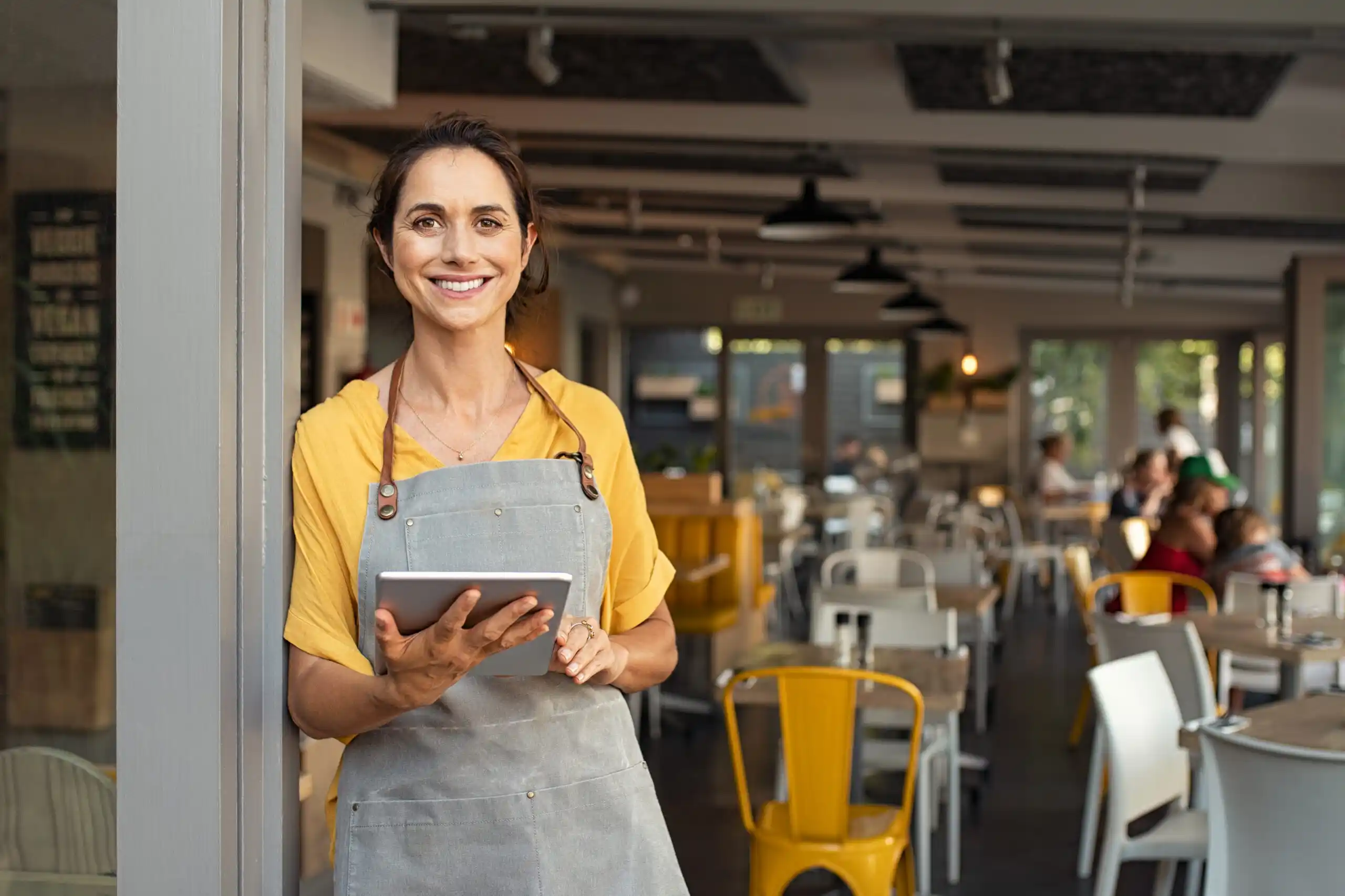 Restaurant Owner Looking at Online Business Resources on Tablet
