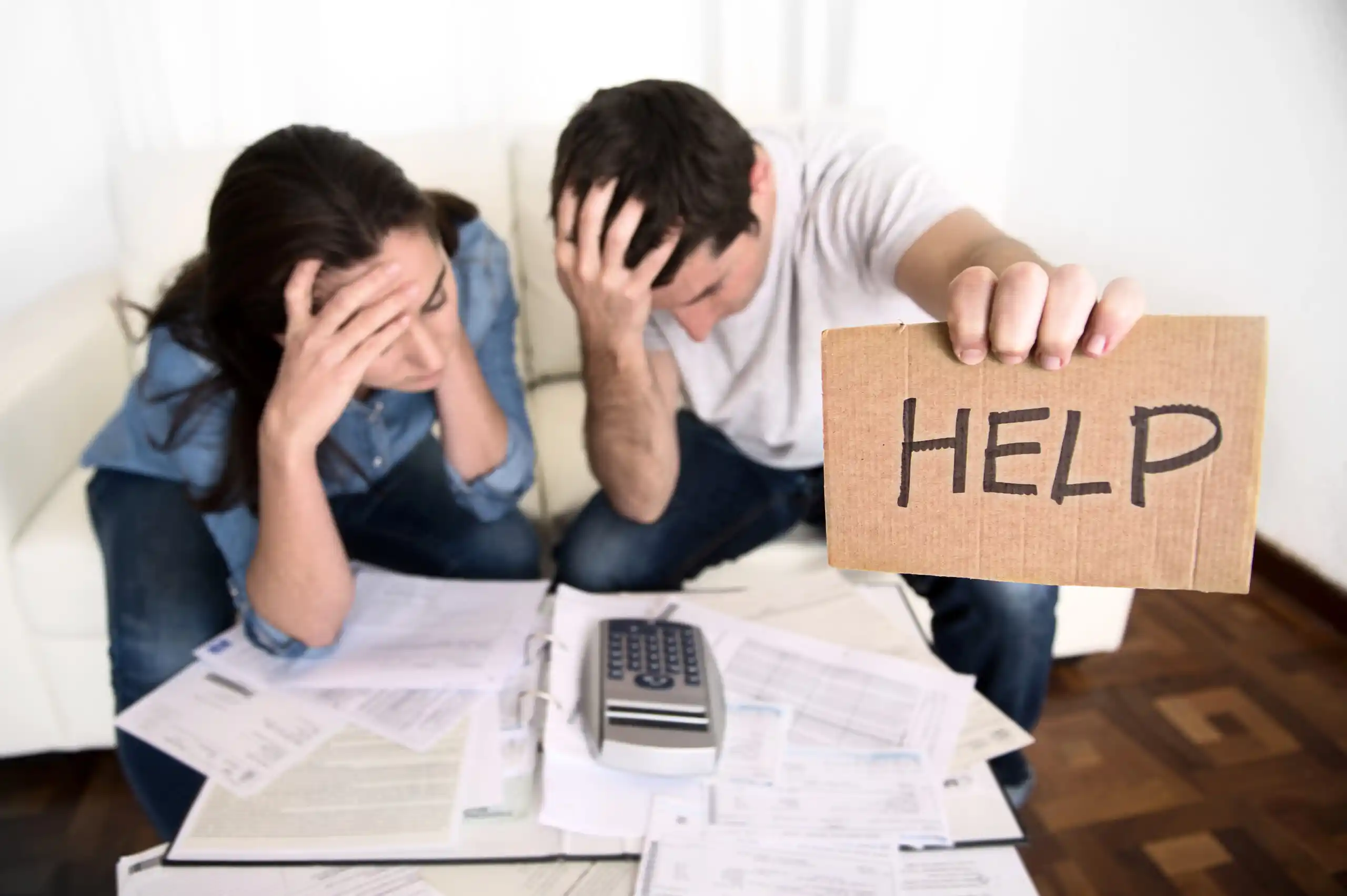 Couple Stressed About Finances Holding Help Sign