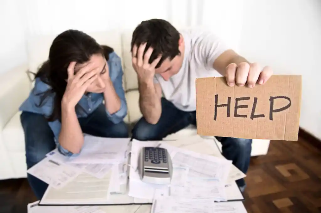 Couple Stressed About Finances Holding Help Sign