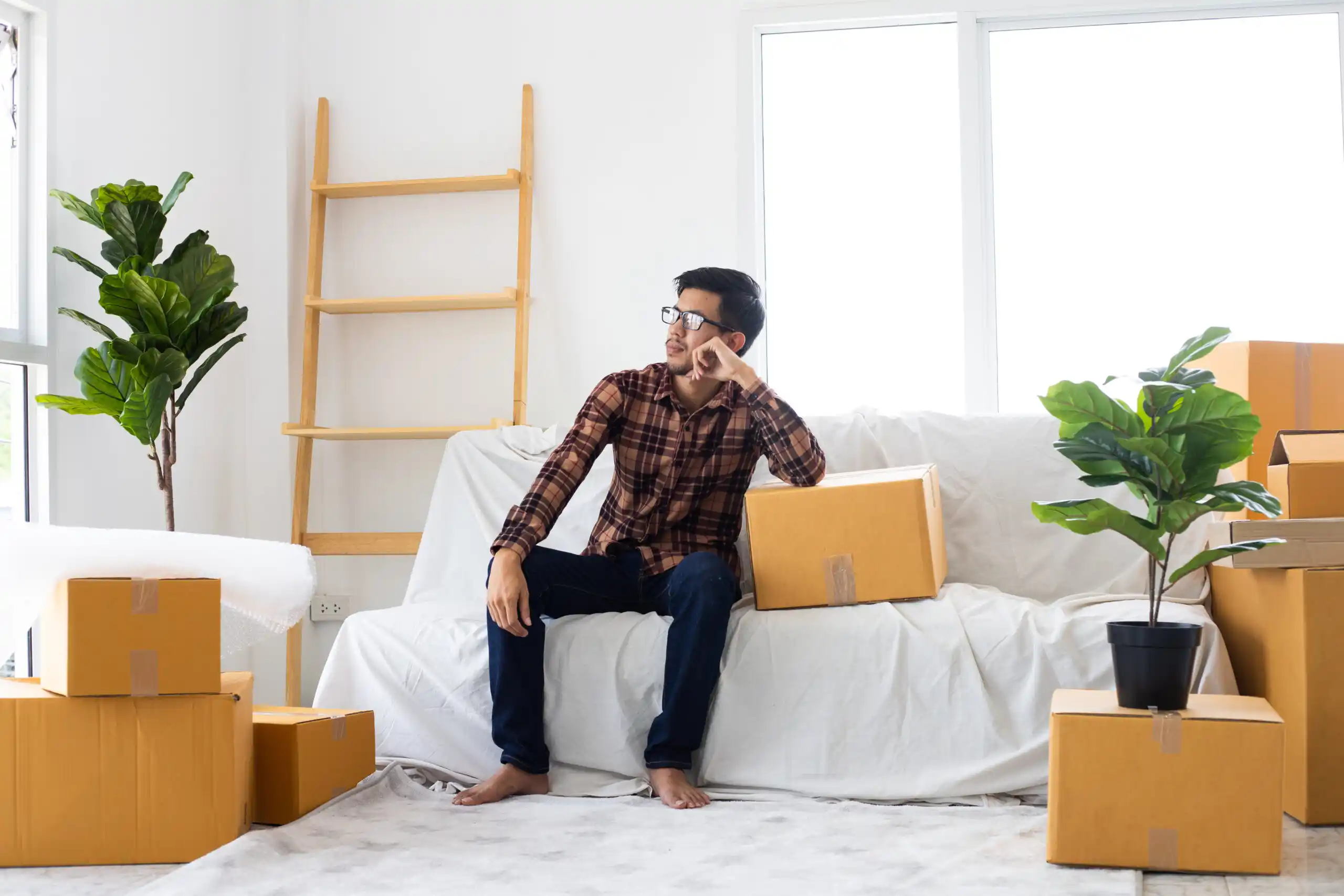 Man Sitting in Room of Moving Boxes