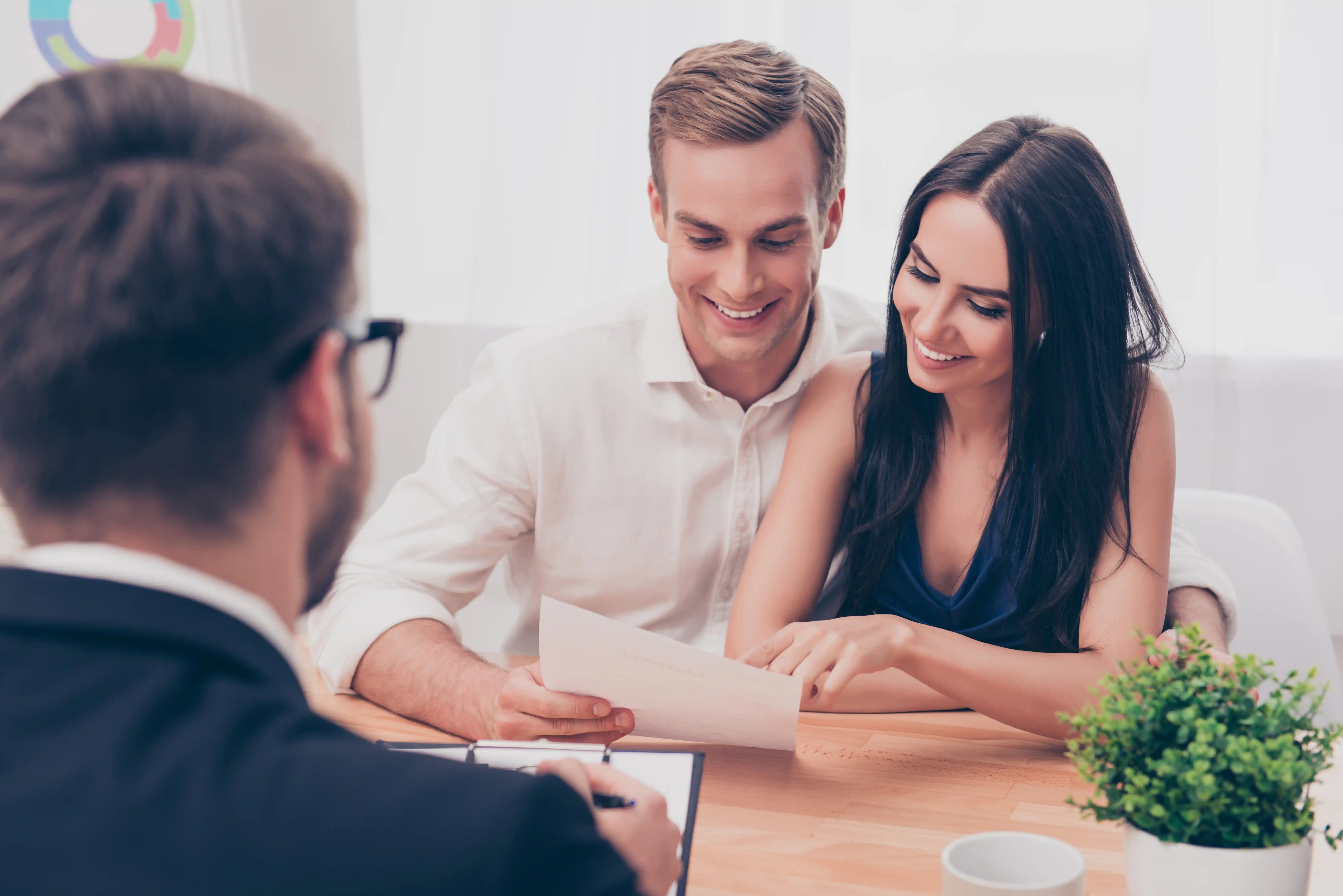 Young couple signing loan paperwork