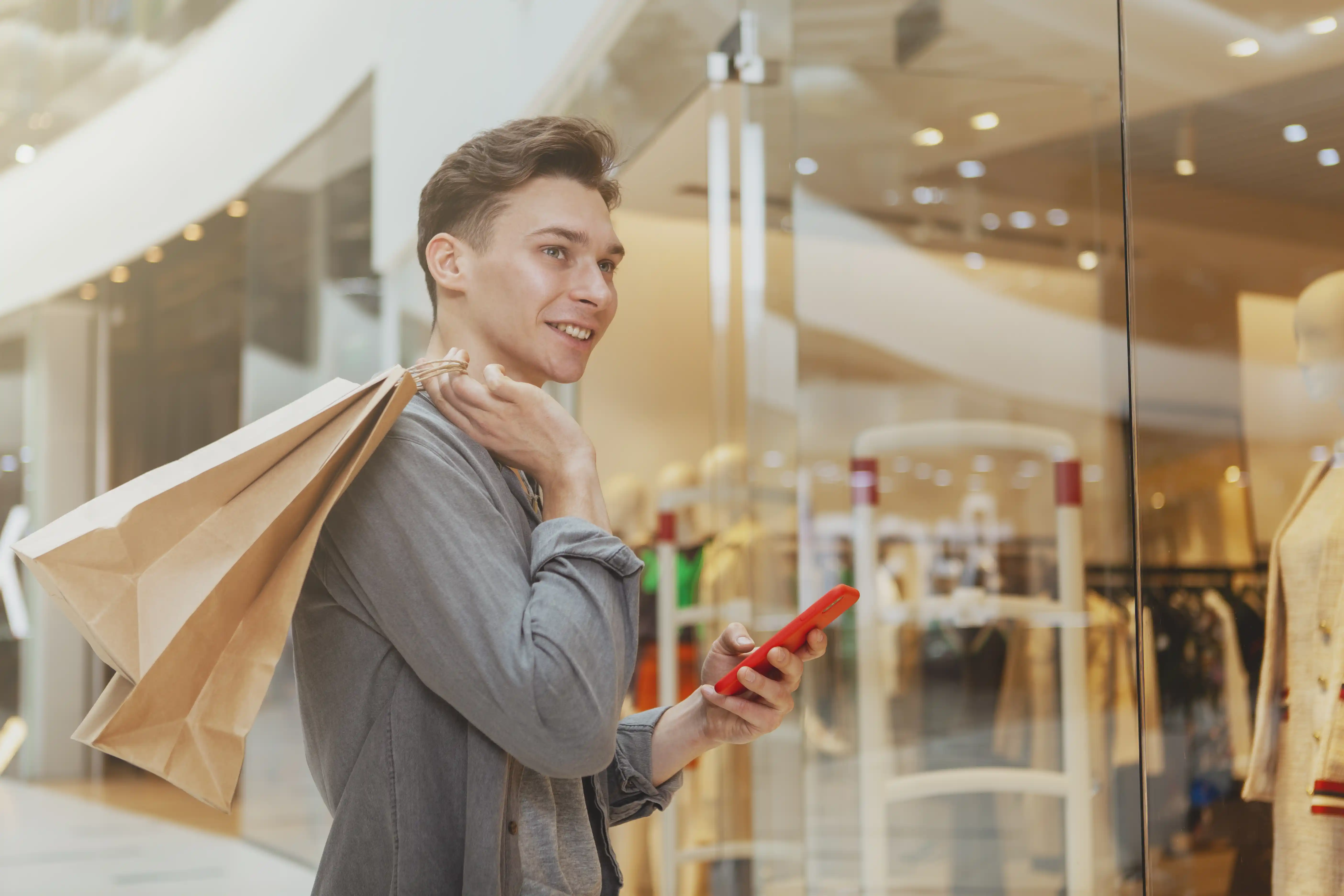 Young man on smartphone while shopping