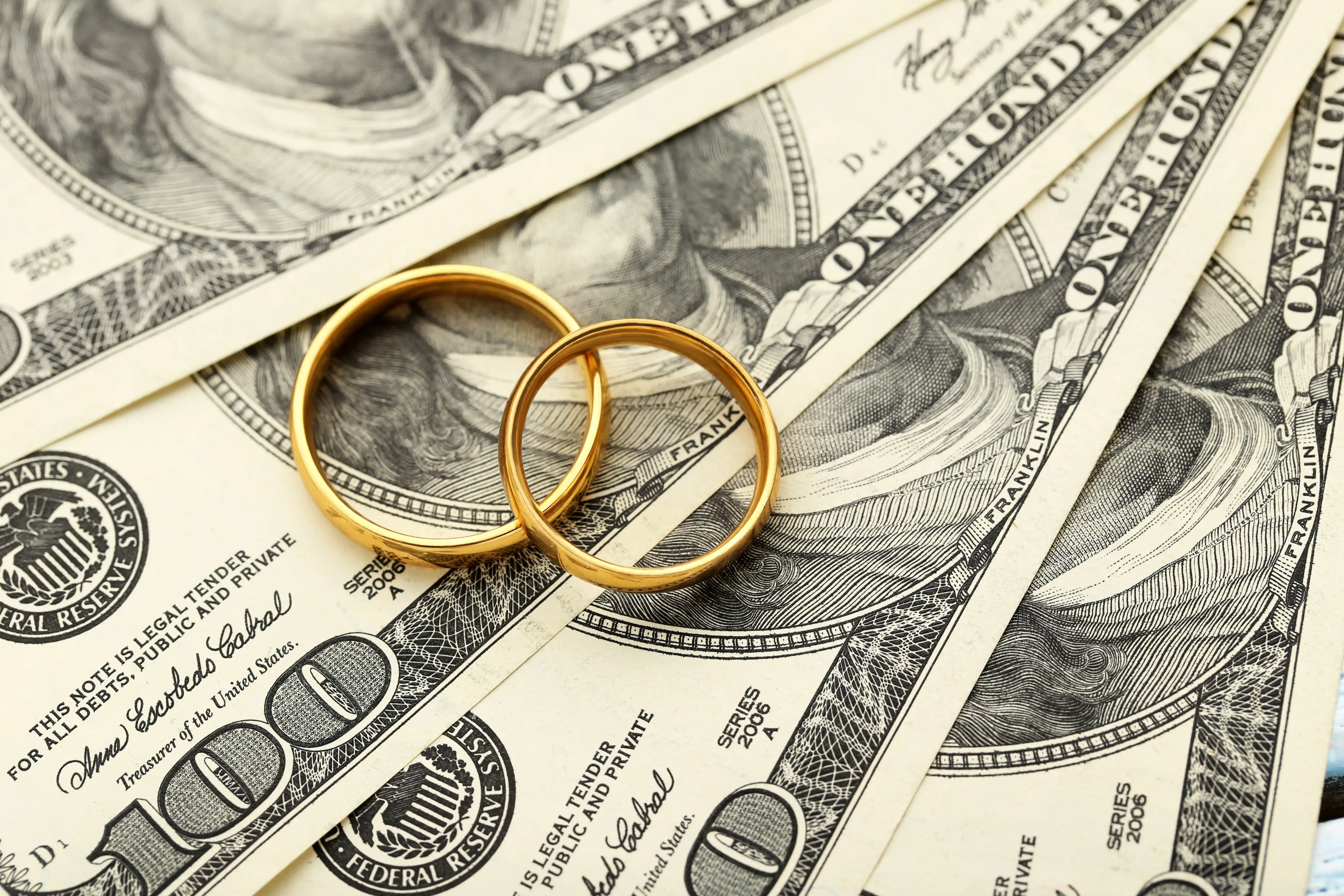 wedding rings on top of cash